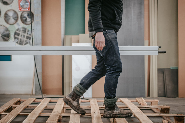 worker walking on a wooden pallet